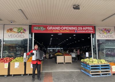 Man playing accordion in front of market