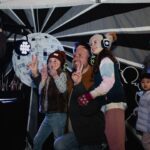 A man posing with two kids at a silent disco